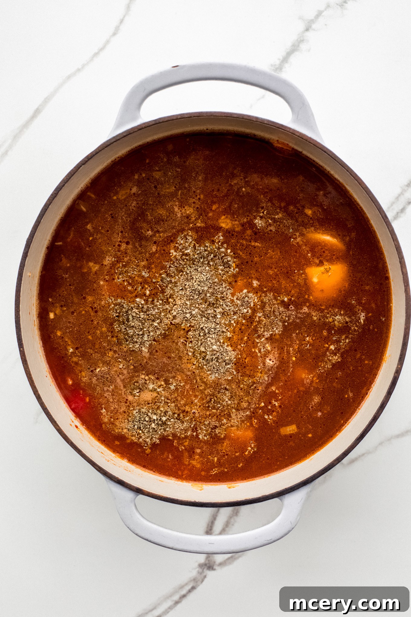 Hearty Garden Orzo Soup 5 tomatoes and broth with vegetables in a soup pot.