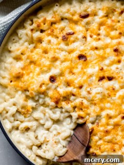 baked mac and cheese with wooden spoon on the side.
