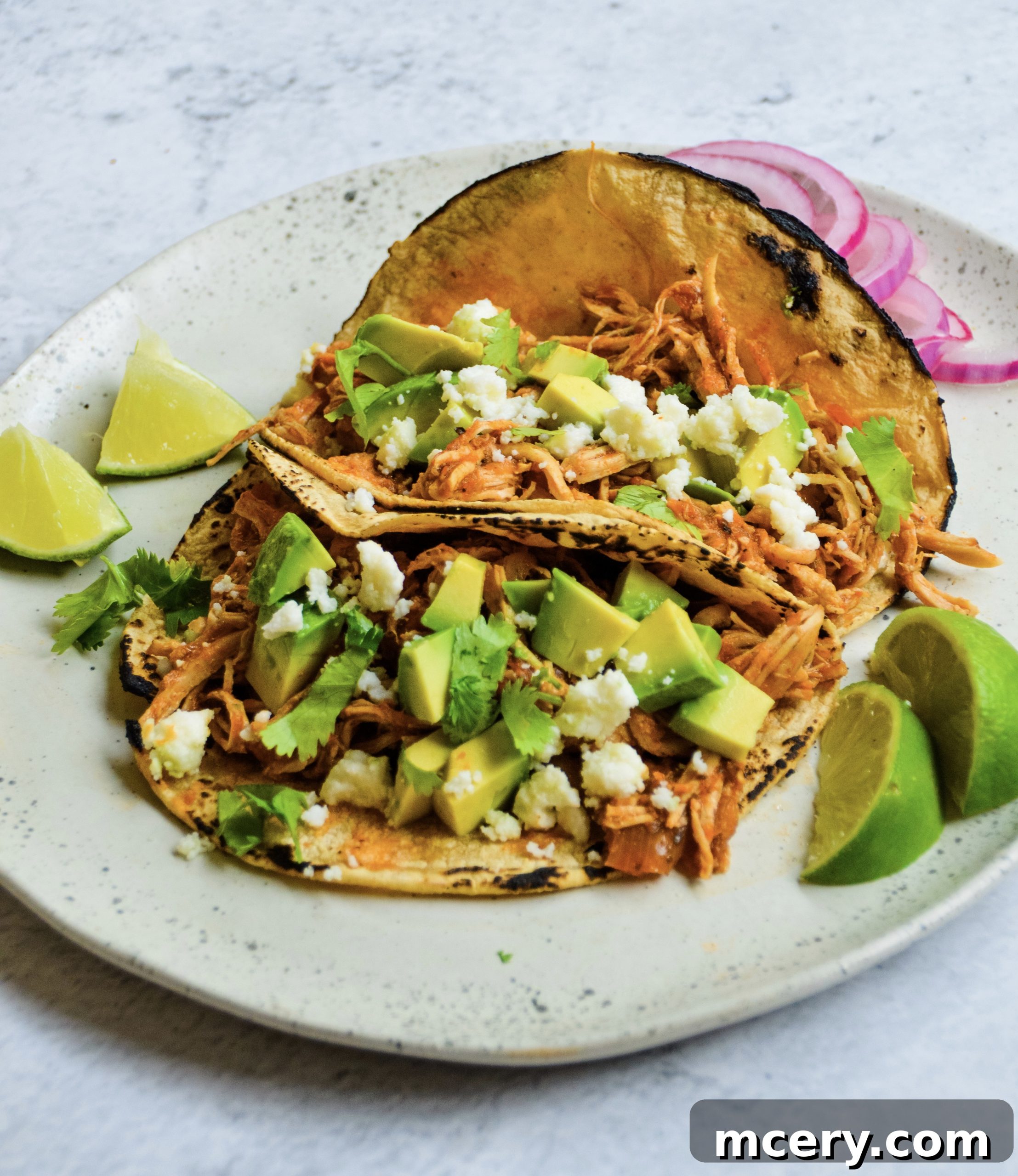 Irresistible Shredded Chicken Tacos 2 Platter of vibrant shredded chicken tacos, garnished with fresh cilantro and lime wedges, ready to be served.