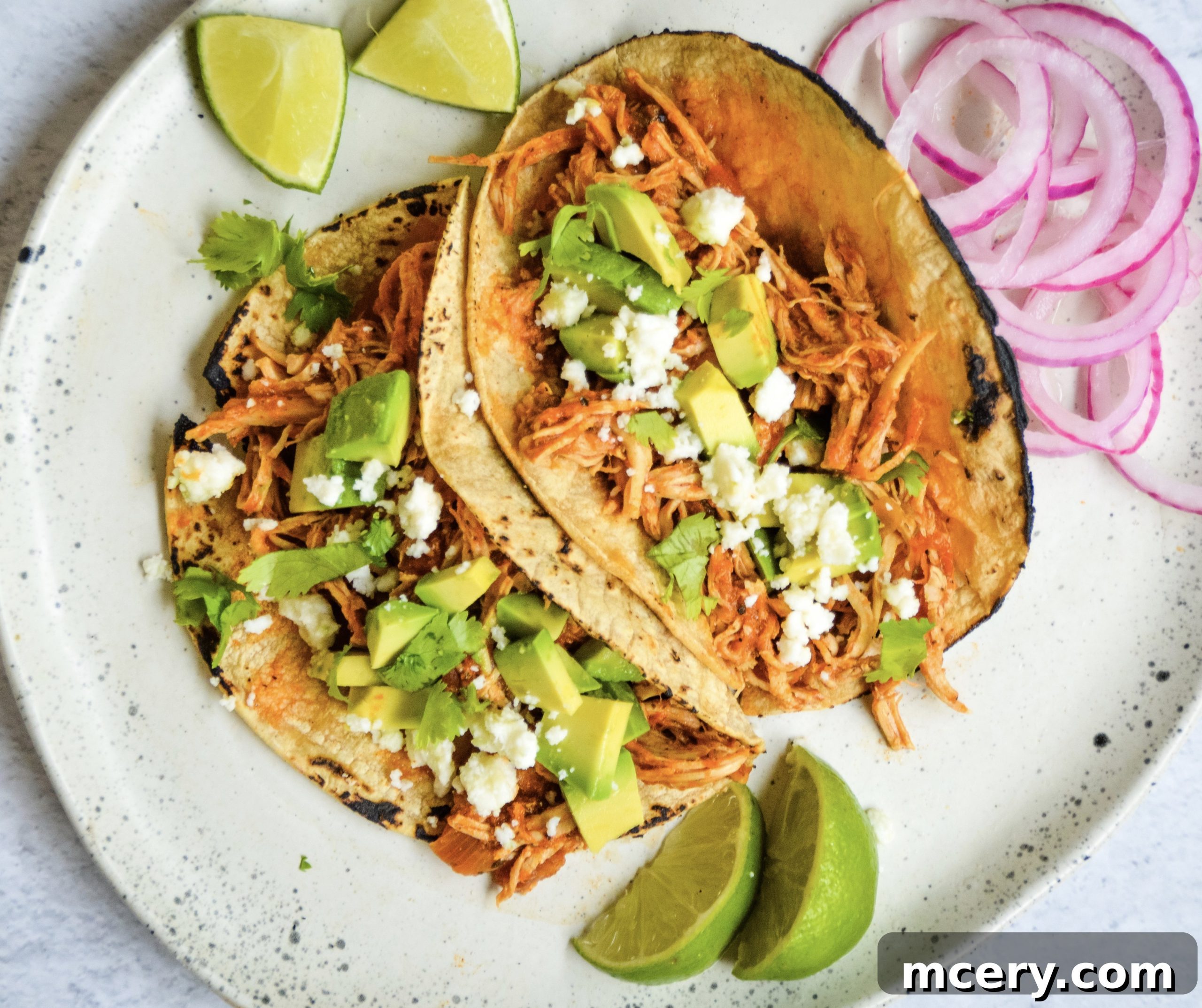Irresistible Shredded Chicken Tacos 4 Sliced onions and minced garlic being sautéed in a Dutch oven with avocado oil.