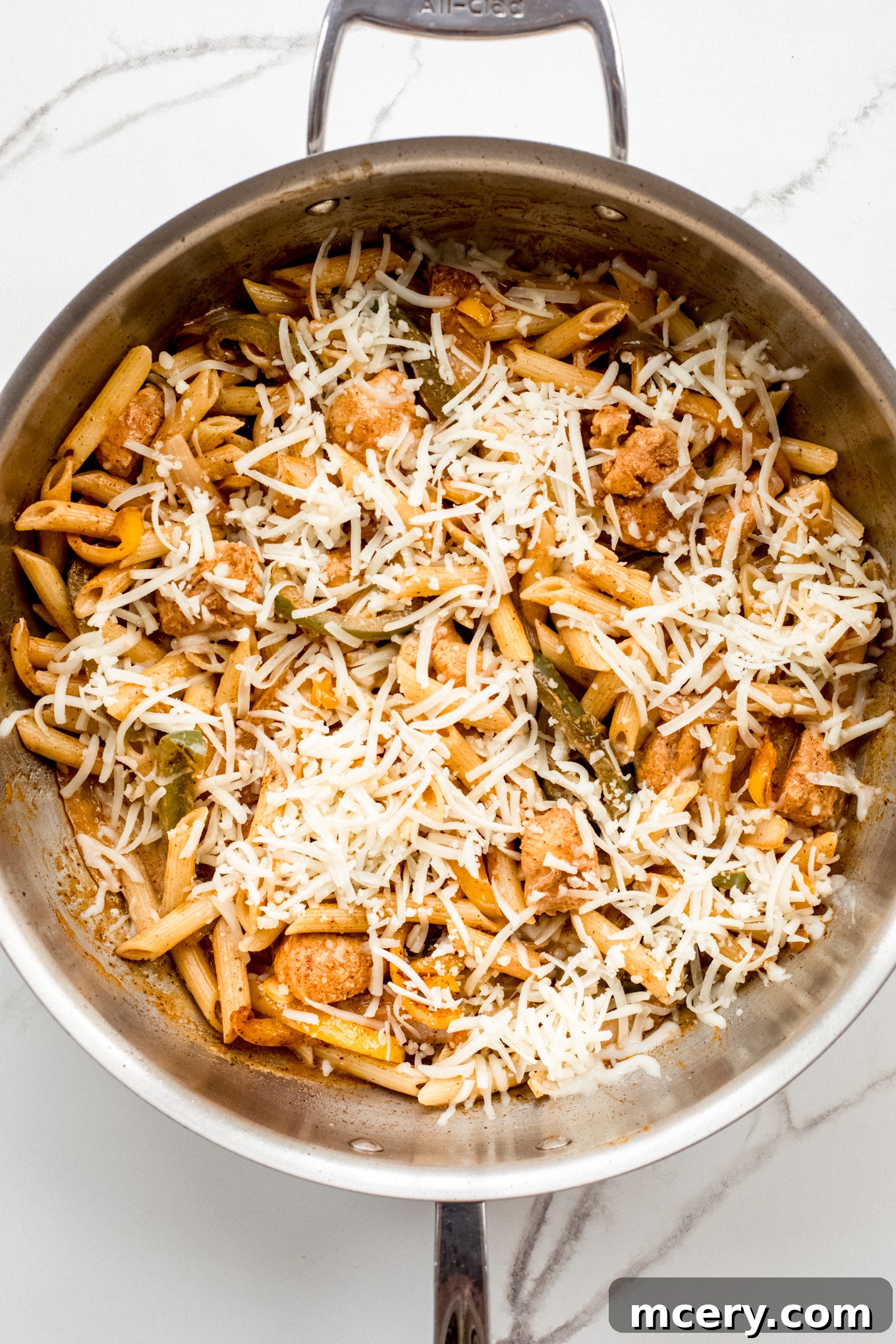 Creamy Chicken Fajita Pasta 11 pasta with chicken and peppers topped with shredded cheese.
