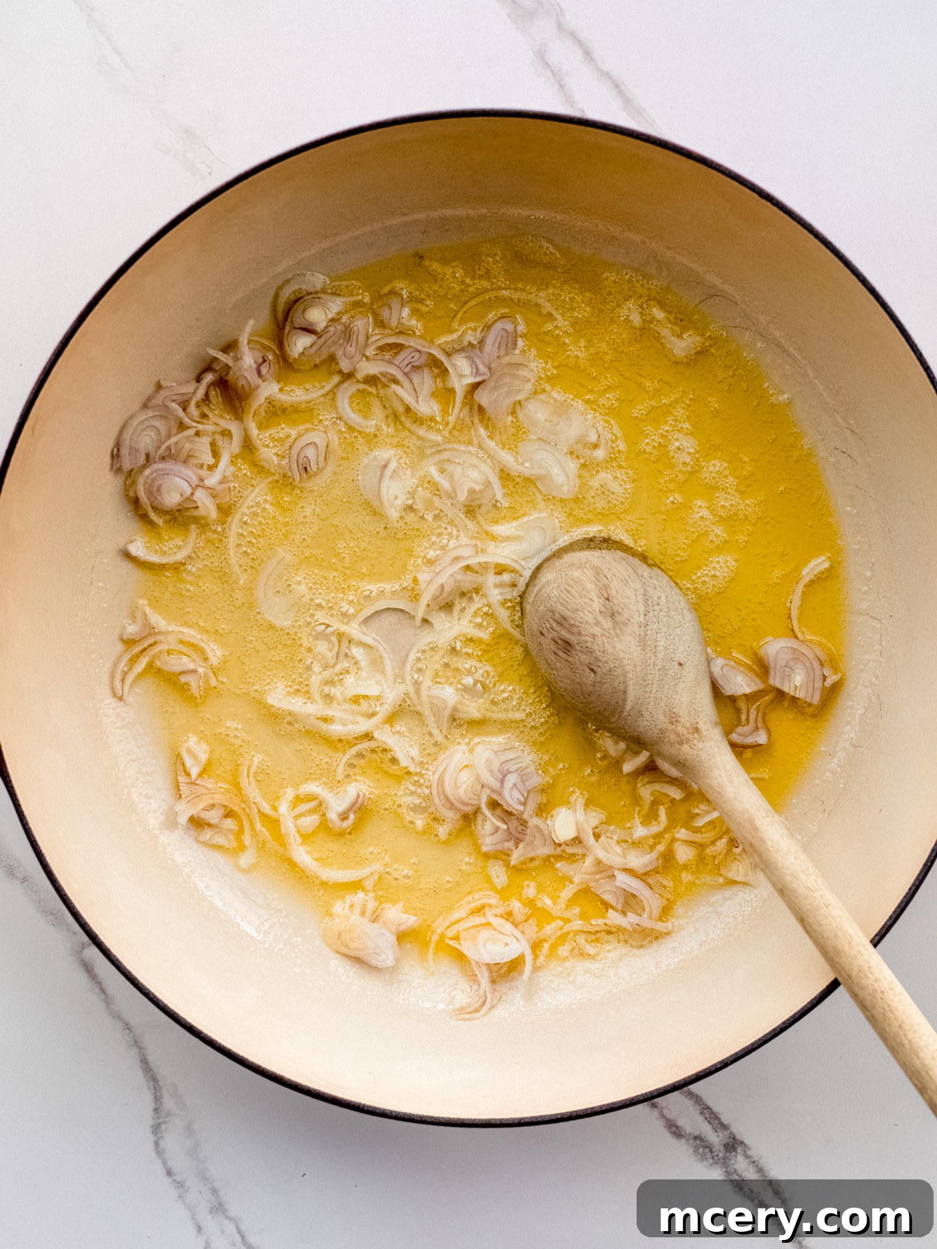 Easy Weeknight Mushroom Stroganoff 4 Sautéed shallots gently cooking in a pan with olive oil and butter.