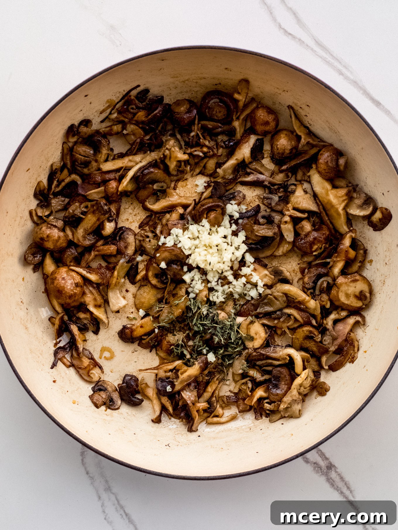 Easy Weeknight Mushroom Stroganoff 5 Mushrooms and garlic sautéing together in a pan until tender and fragrant.