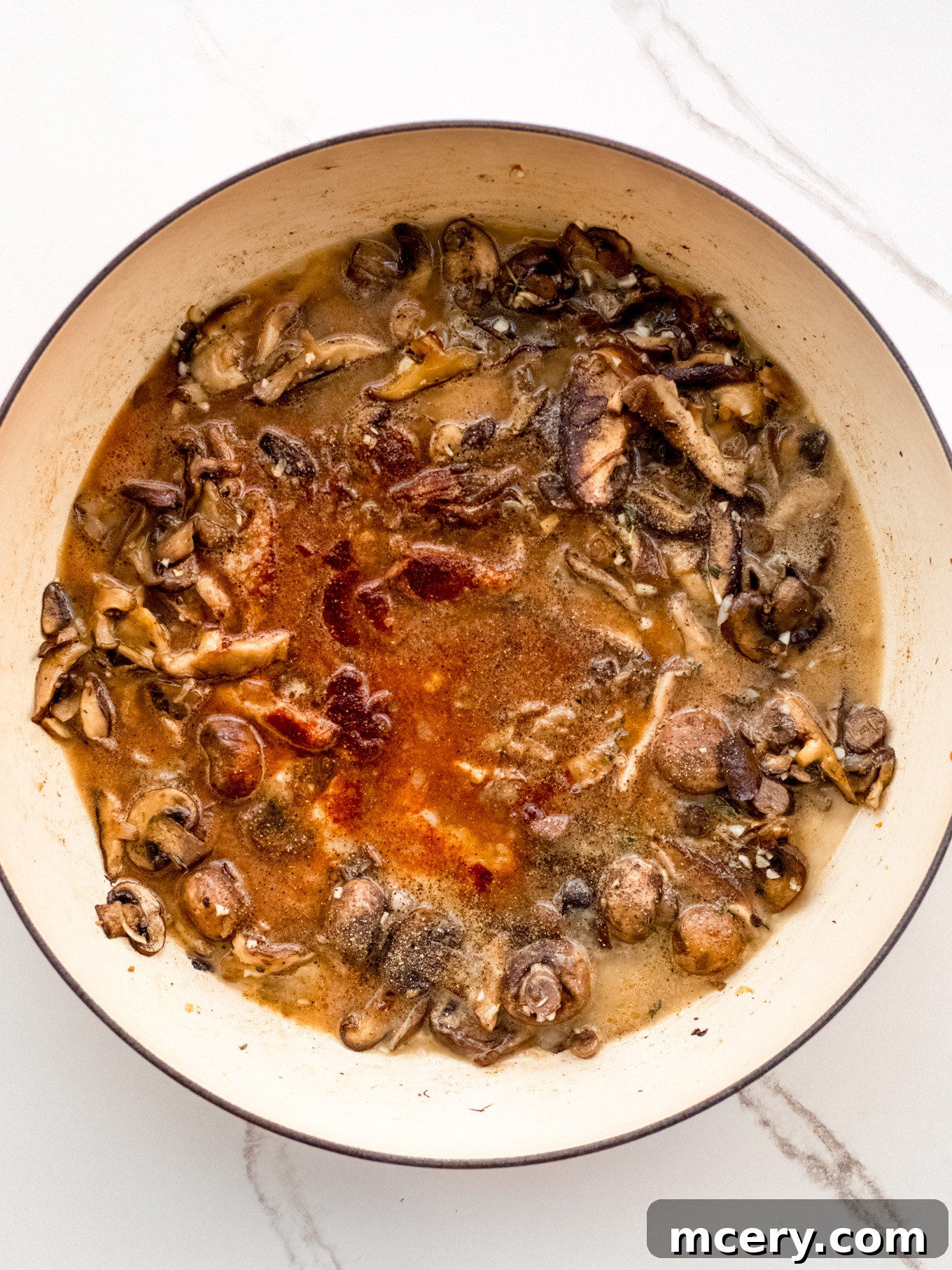 Easy Weeknight Mushroom Stroganoff 7 Mushroom mixture simmering in a rich, flavorful liquid with spices.
