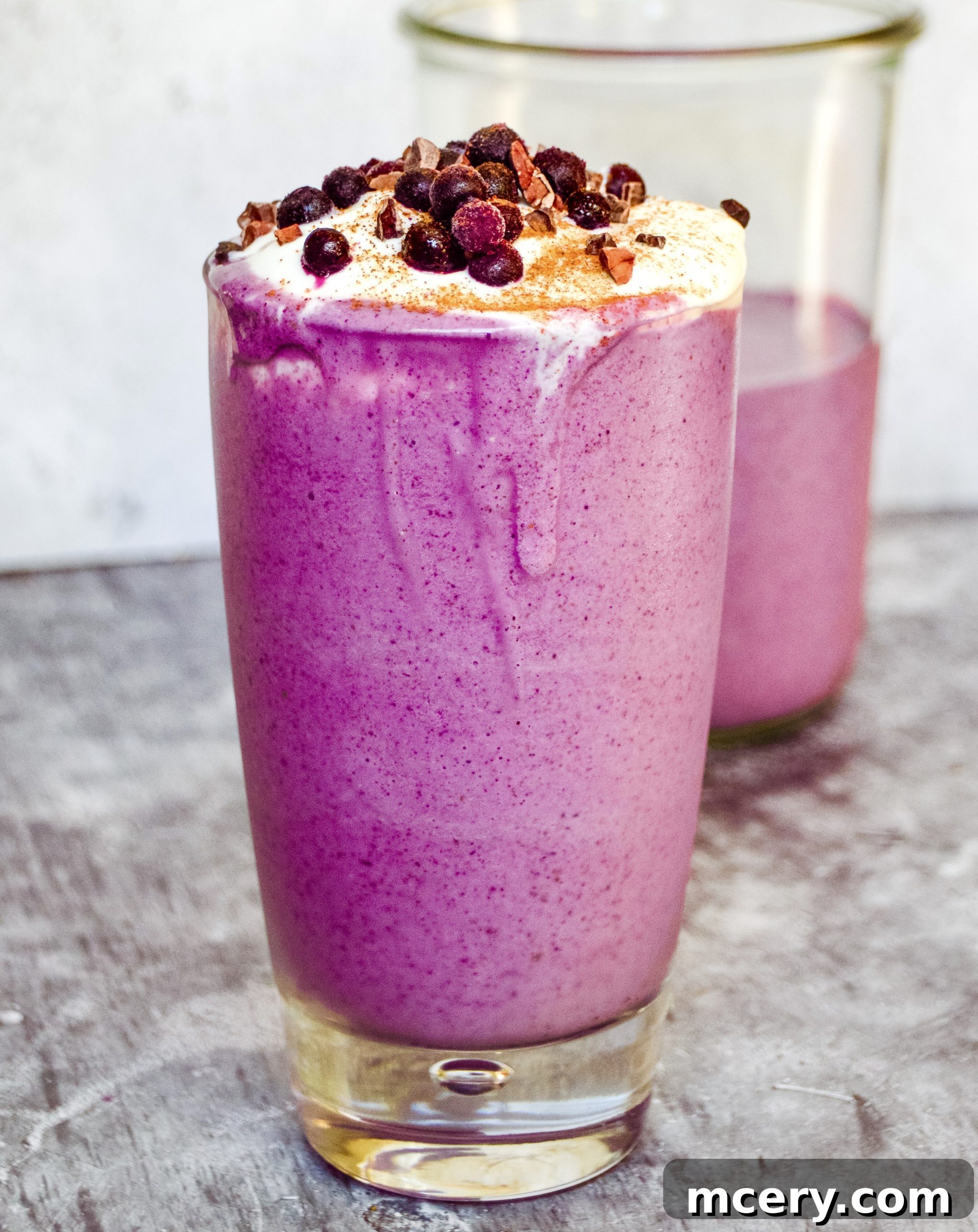 A top-down view of the Pregnancy Blueberry Smoothie, garnished with whole blueberries and a sprinkle of chia seeds, presented in a clear glass.