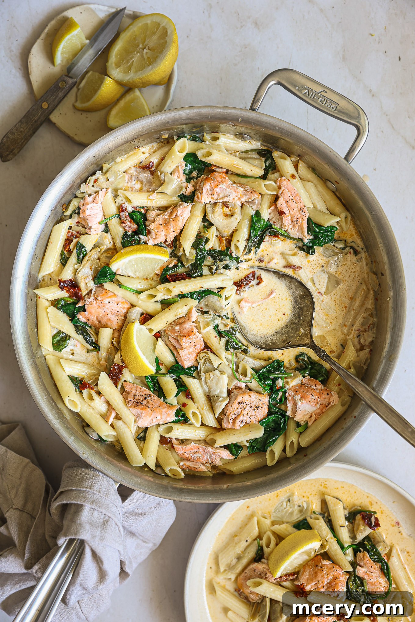 salmon pasta in cream sauce, garnished with fresh herbs and a lemon wedge, ready to be served.