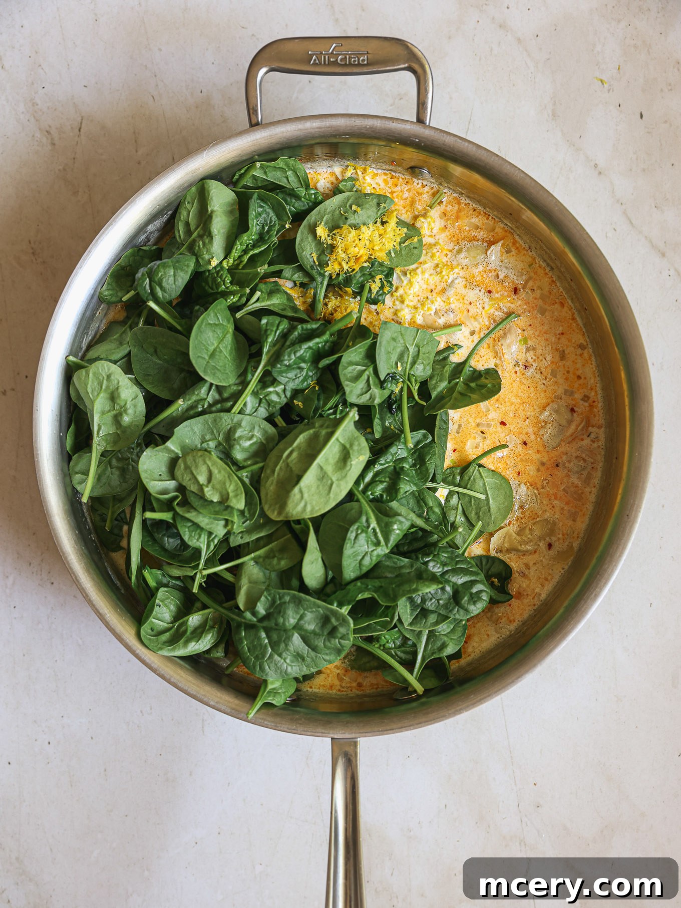 fresh spinach wilting into the creamy sauce with sun-dried tomatoes and artichokes.