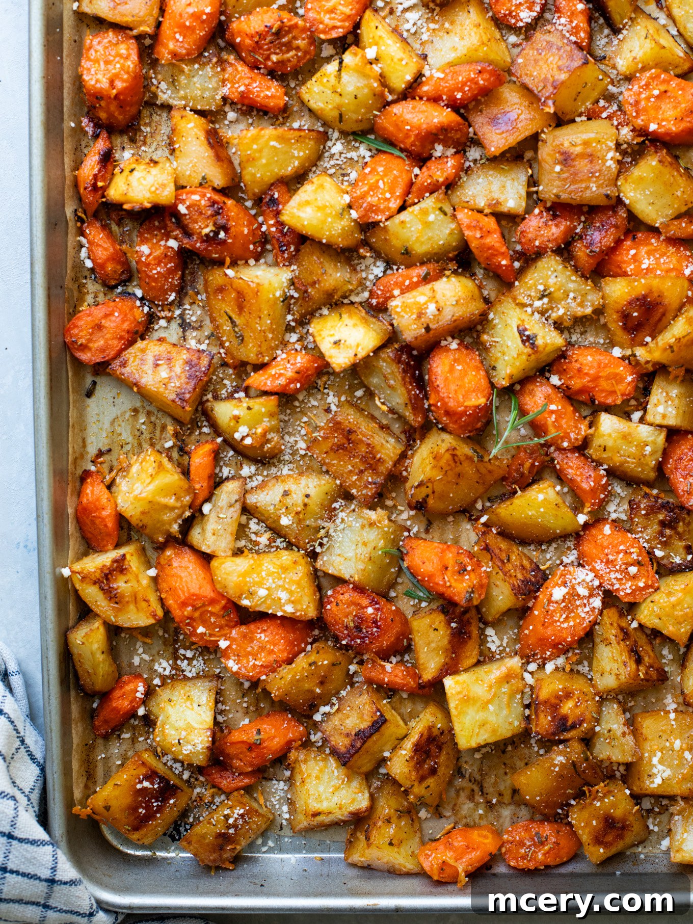 Caramelized Carrots and Crispy Potatoes 2 roasted carrots and potatoes on a sheet pan, golden brown and perfectly cooked.