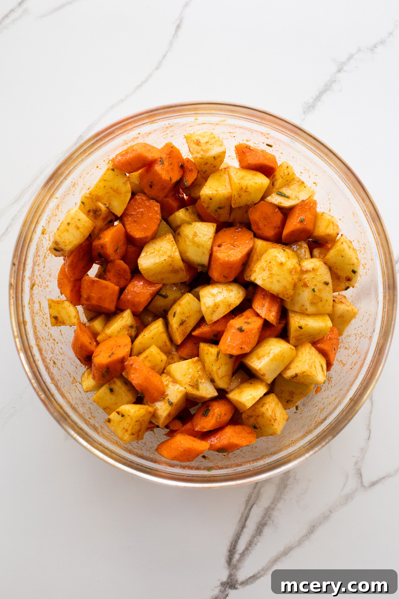 Caramelized Carrots and Crispy Potatoes 5 mixed potatoes and carrots with spices in a bowl.