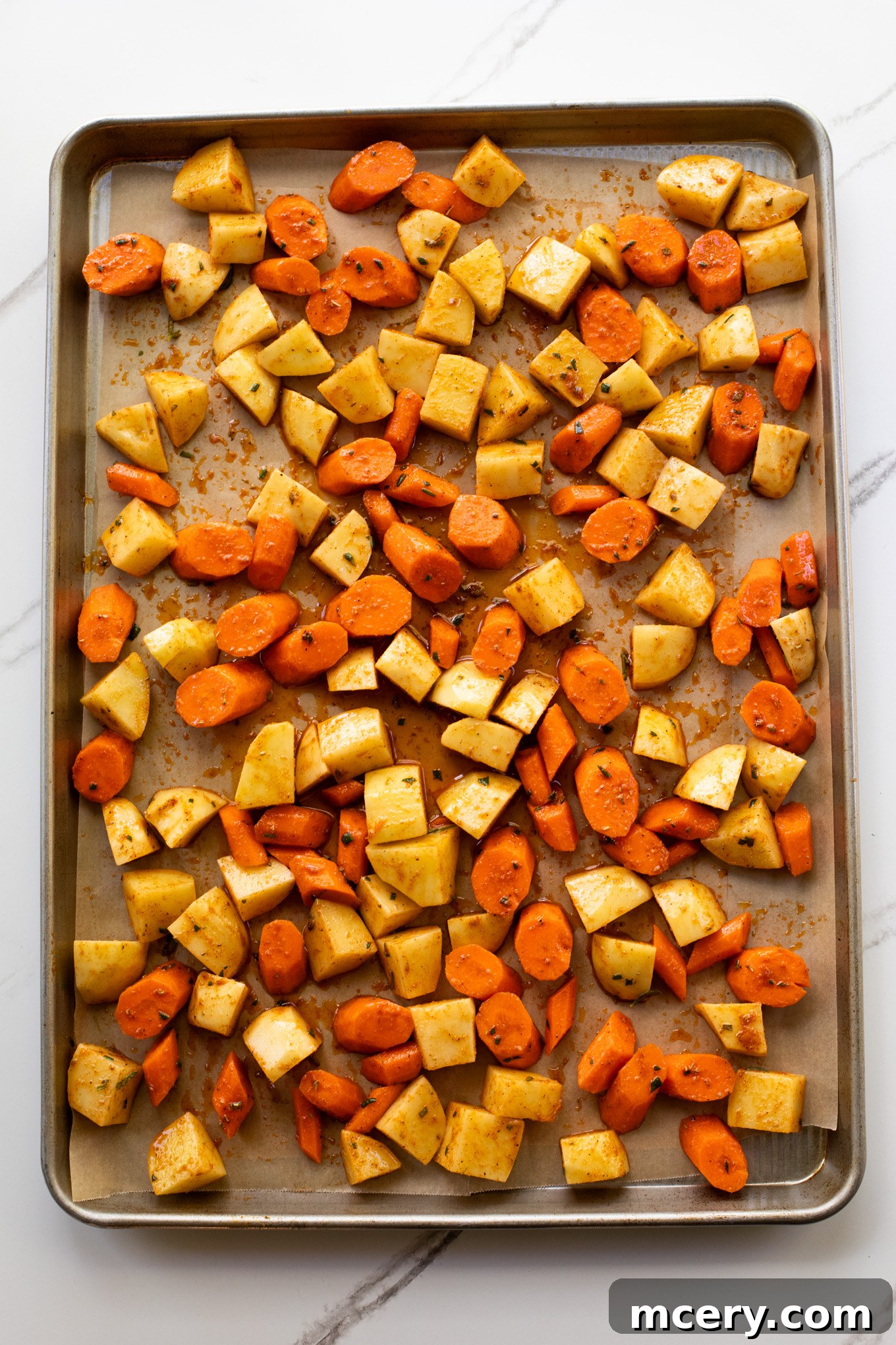 Caramelized Carrots and Crispy Potatoes 6 cut up potatoes and carrots on a baking sheet.