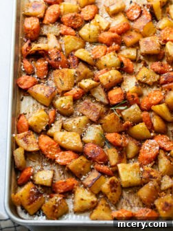 close up carrots with potatoes on a sheet pan.