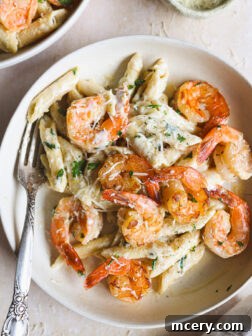 lemon shrimp pasta in a white bowl garnished wiht parsley.