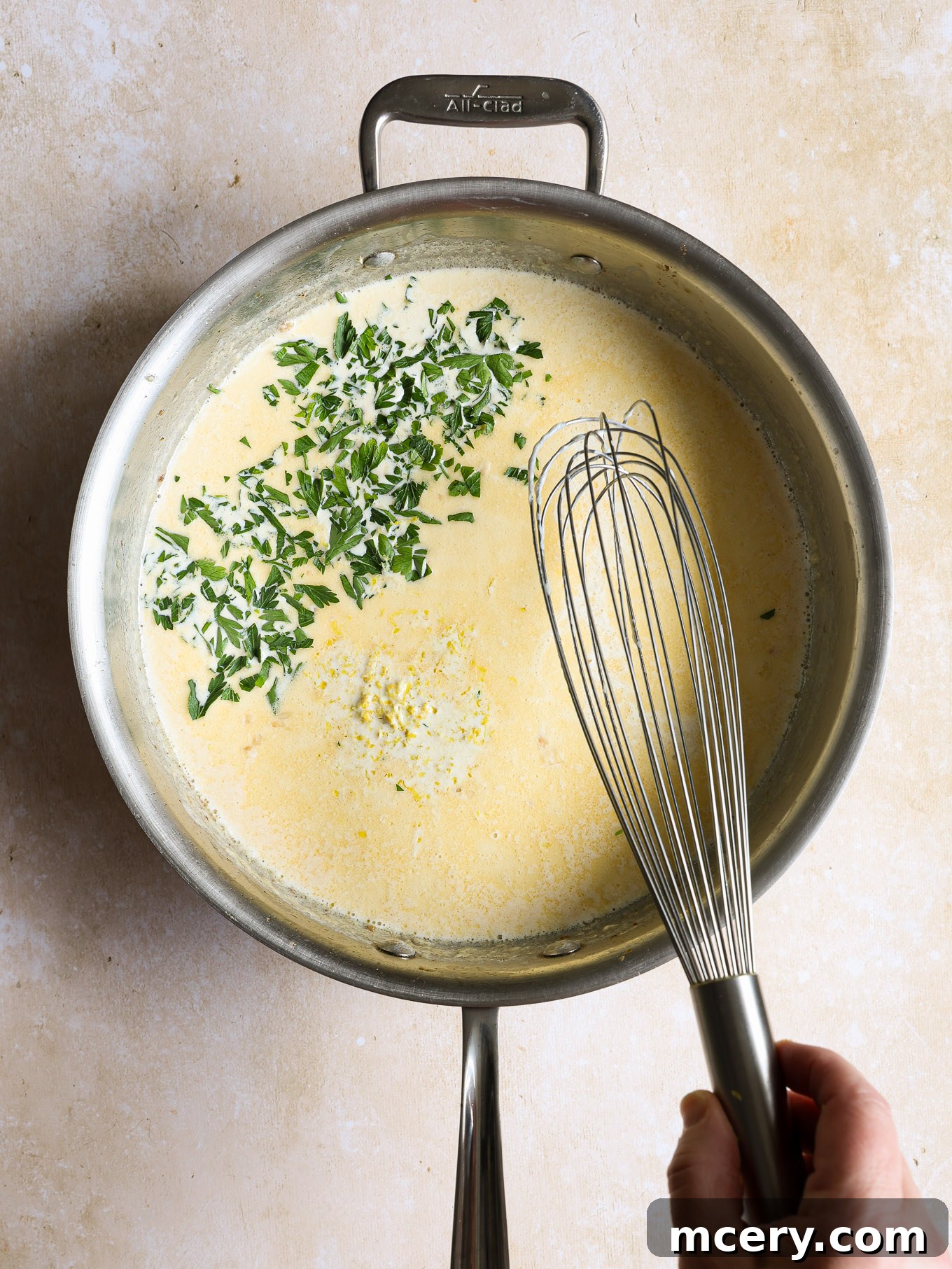 Zesty Lemon Shrimp Pasta 8 lemon cream sauce with parsley in a saucepan.