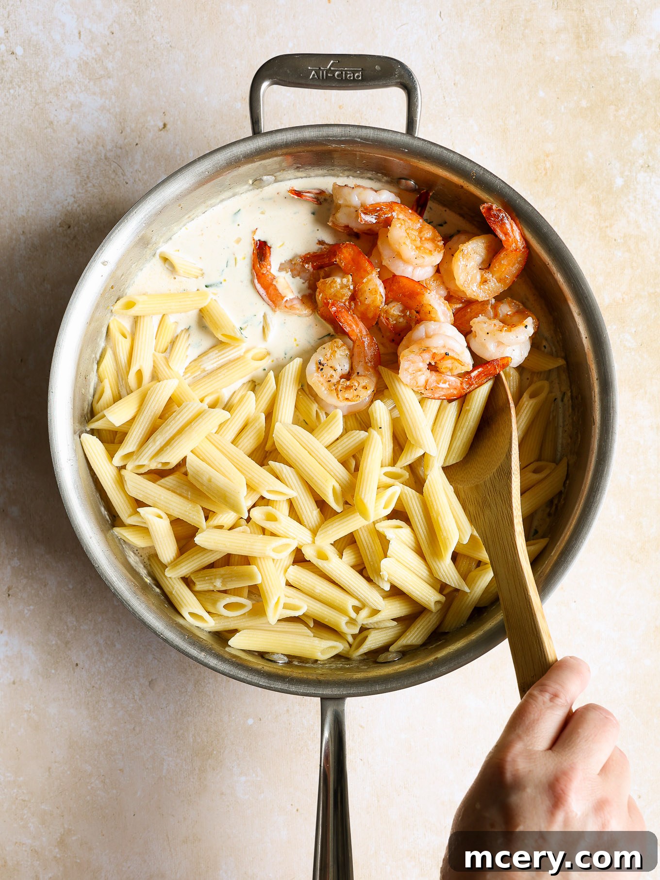 Zesty Lemon Shrimp Pasta 9 penne pasta and cooked shrimp in cream sauce in saucepan.
