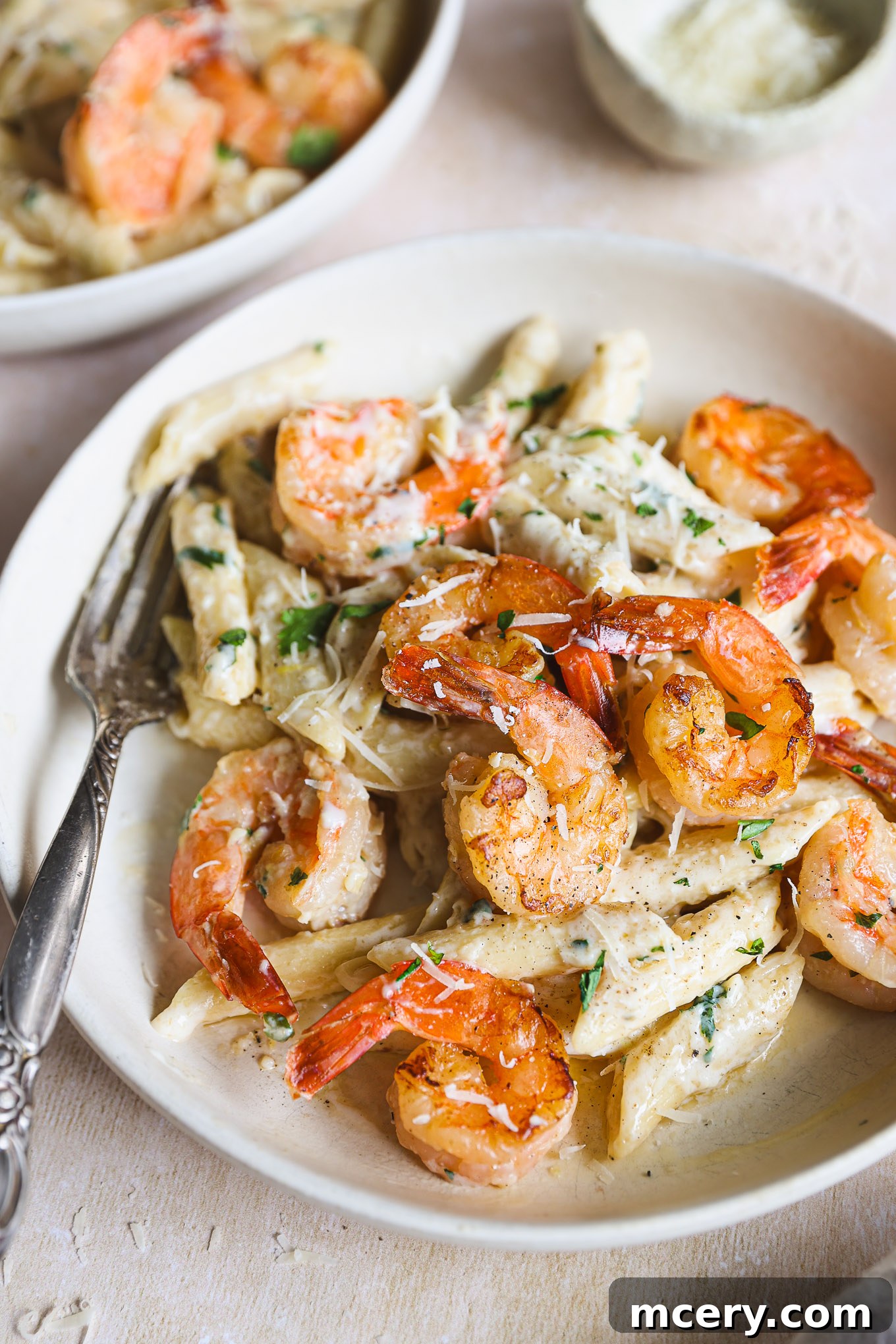 Zesty Lemon Shrimp Pasta 10 close up lemon and shrimp pasta on a plate with a side of fork.