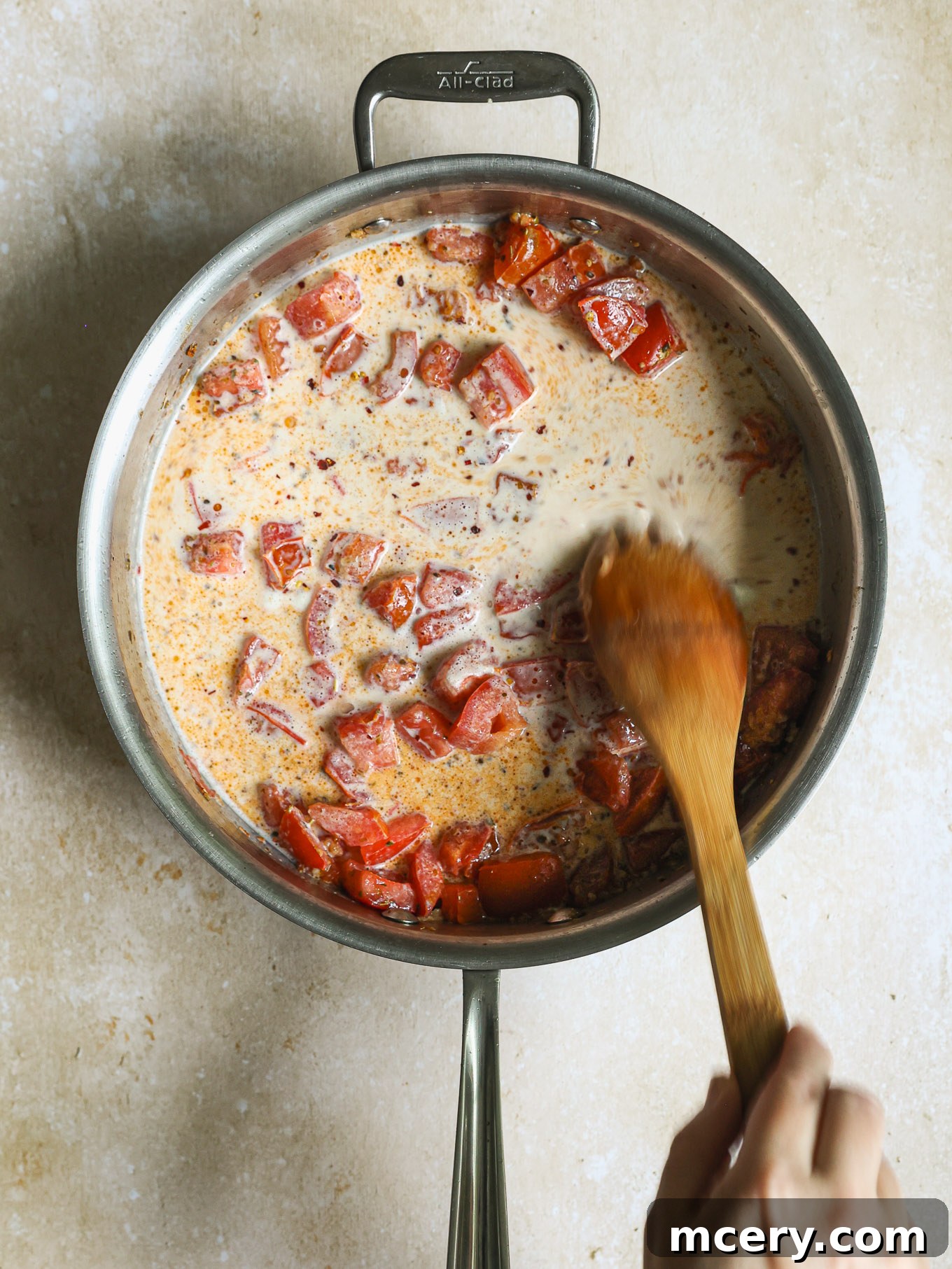 Sun-Kissed Tomato Basil Chicken 5 diced tomatoes in cream in a saute pan.
