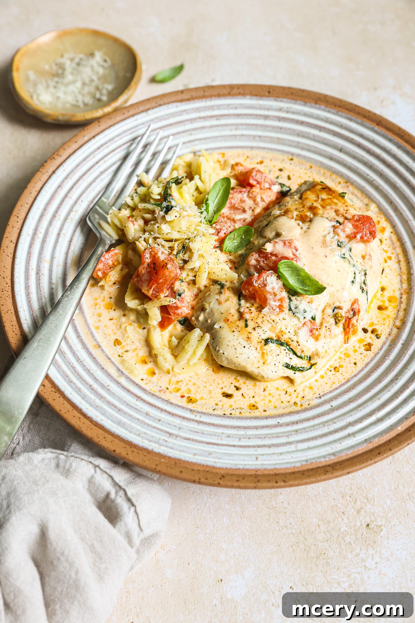 Sun-Kissed Tomato Basil Chicken 8 chicken breast in tomato cream sauce over orzo in a bowl.