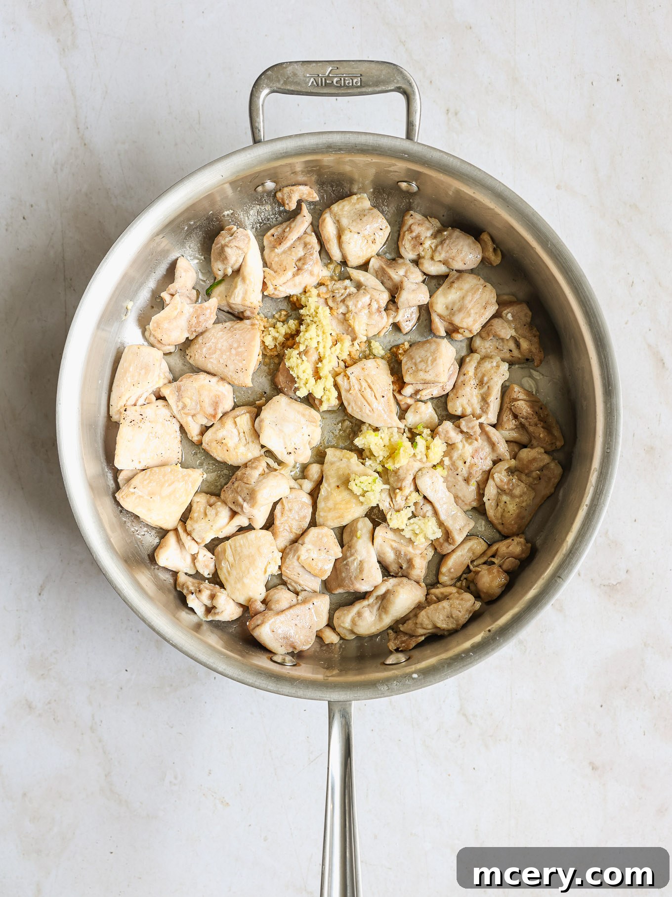 Whip Up Delicious Homemade Chicken Teriyaki 7 Cooked chicken pieces with minced garlic and grated ginger in a hot skillet.