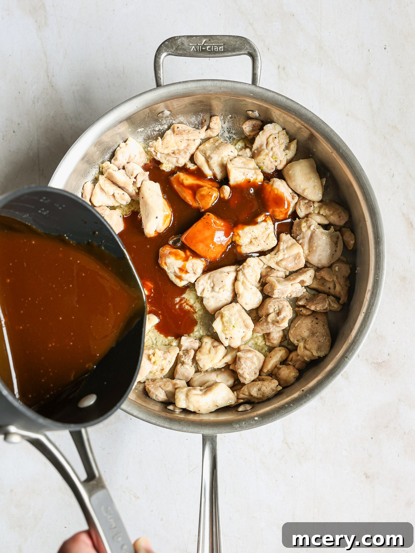 Whip Up Delicious Homemade Chicken Teriyaki 8 Pouring the homemade teriyaki sauce over the cooked chicken in the skillet.