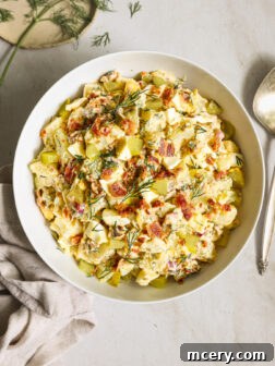 potato salad with bacon in a white bowl.