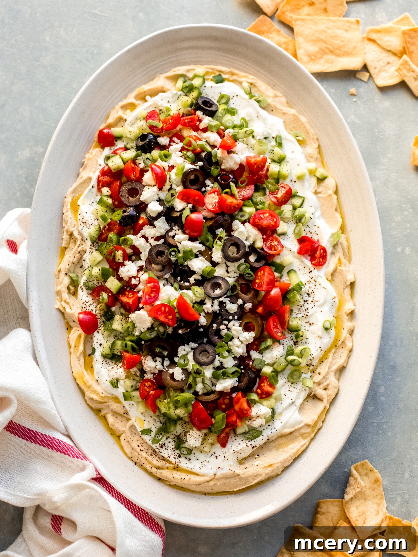Stacked Hummus Delight 2 Exquisite layered hummus dip with Greek yogurt and fresh Mediterranean toppings