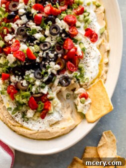 Loaded hummus dip with fresh veggies and creamy yogurt, ready to serve