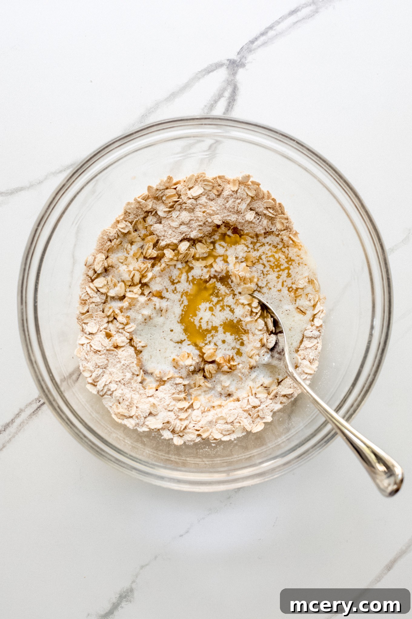 Golden Oat Topped Blueberry Crisp 7 Melted butter being added to the oat and flour mixture in a bowl.