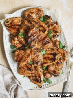 grilled chicken thighs on a platter garnished with cilantro.