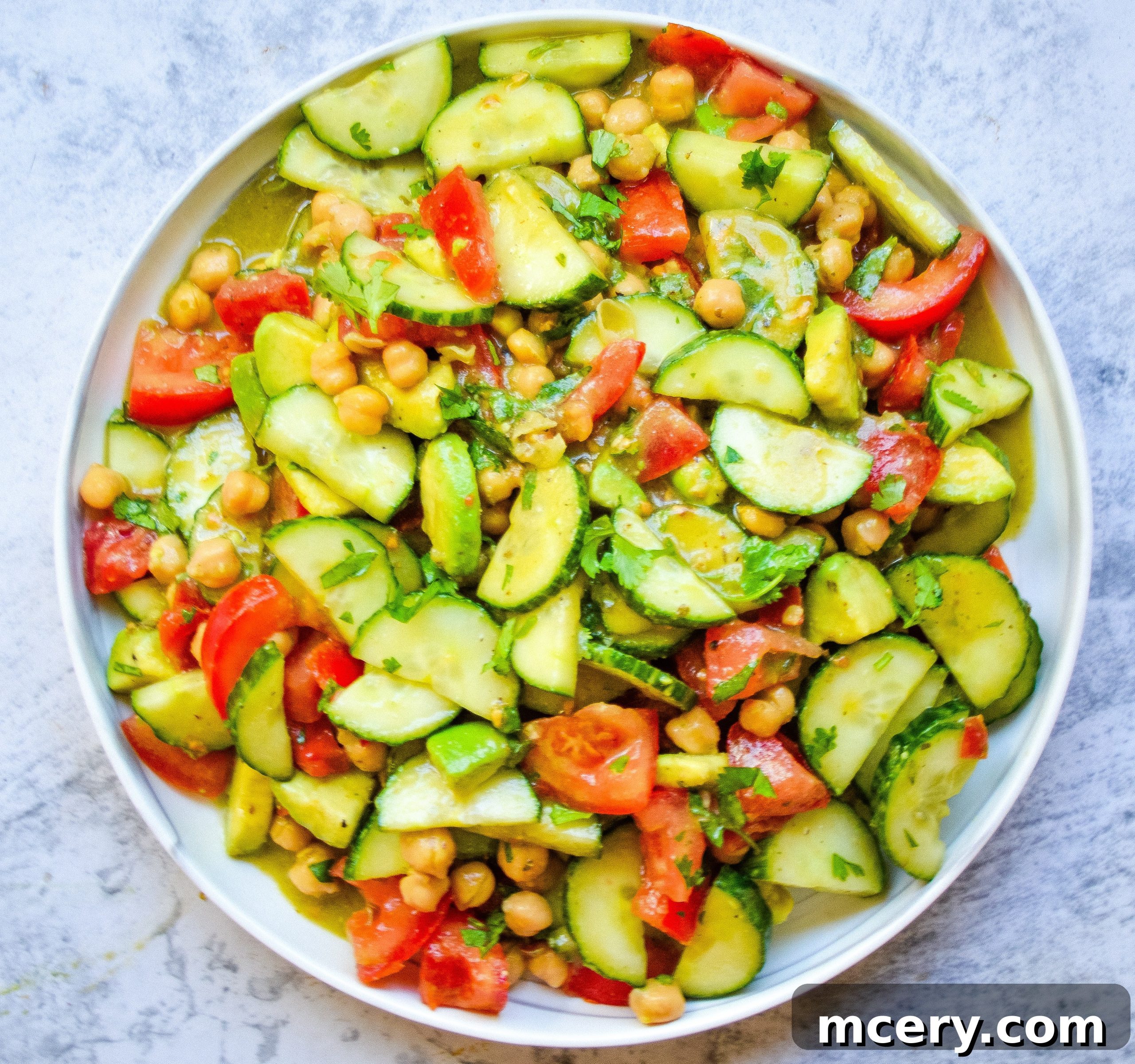 Refreshing Cucumber Avocado Salad with Tomatoes and Chickpeas 3 Close-up shot of the fresh ingredients for the cucumber salad, including diced cucumbers, tomatoes, and chickpeas, ready to be mixed.