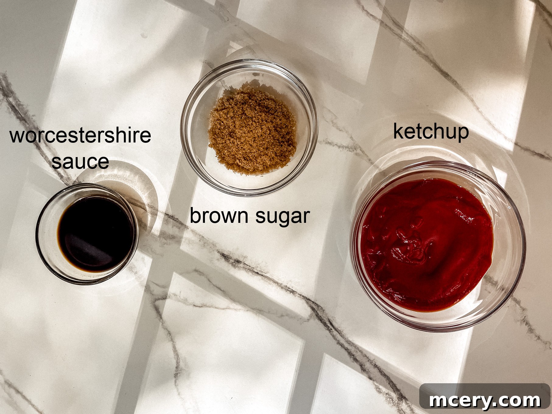 Three Ingredient BBQ Magic 3 Three essential ingredients for homemade BBQ sauce: a bottle of ketchup, a bowl of dark brown sugar, and a bottle of Worcestershire sauce, artfully arranged on a wooden surface.