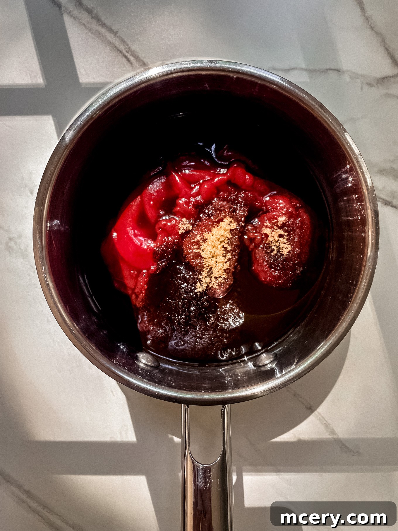 Three Ingredient BBQ Magic 4 Ketchup, dark brown sugar, and Worcestershire sauce are being combined and stirred together in a small saucepan, ready for cooking.