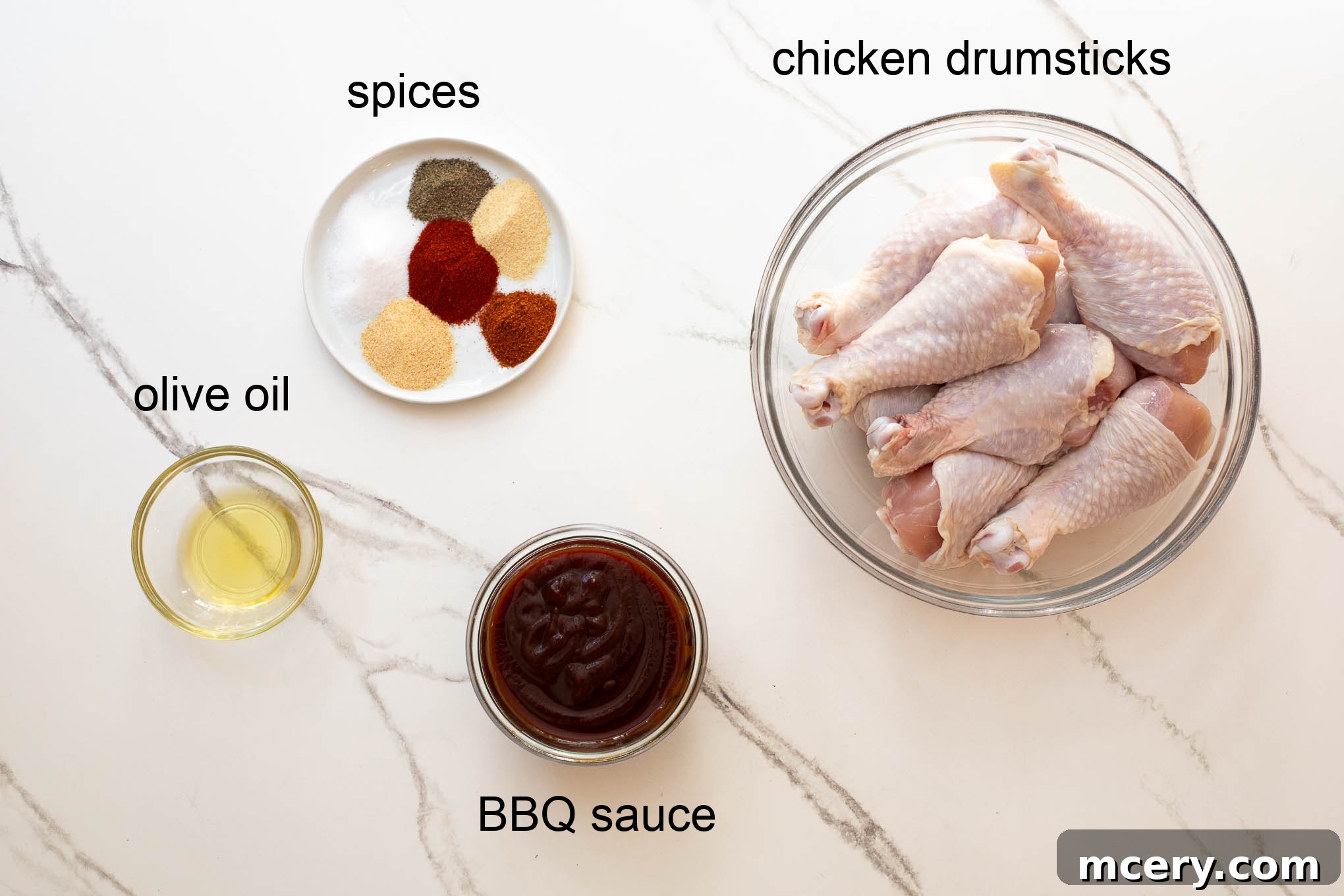 Sweet & Smoky Oven-Baked BBQ Drumsticks 3 Ingredients for oven baked BBQ chicken legs laid out on a wooden surface.