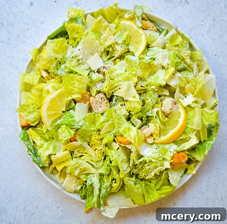 A bowl of creamy Caesar dressing, ready to be tossed with salad.