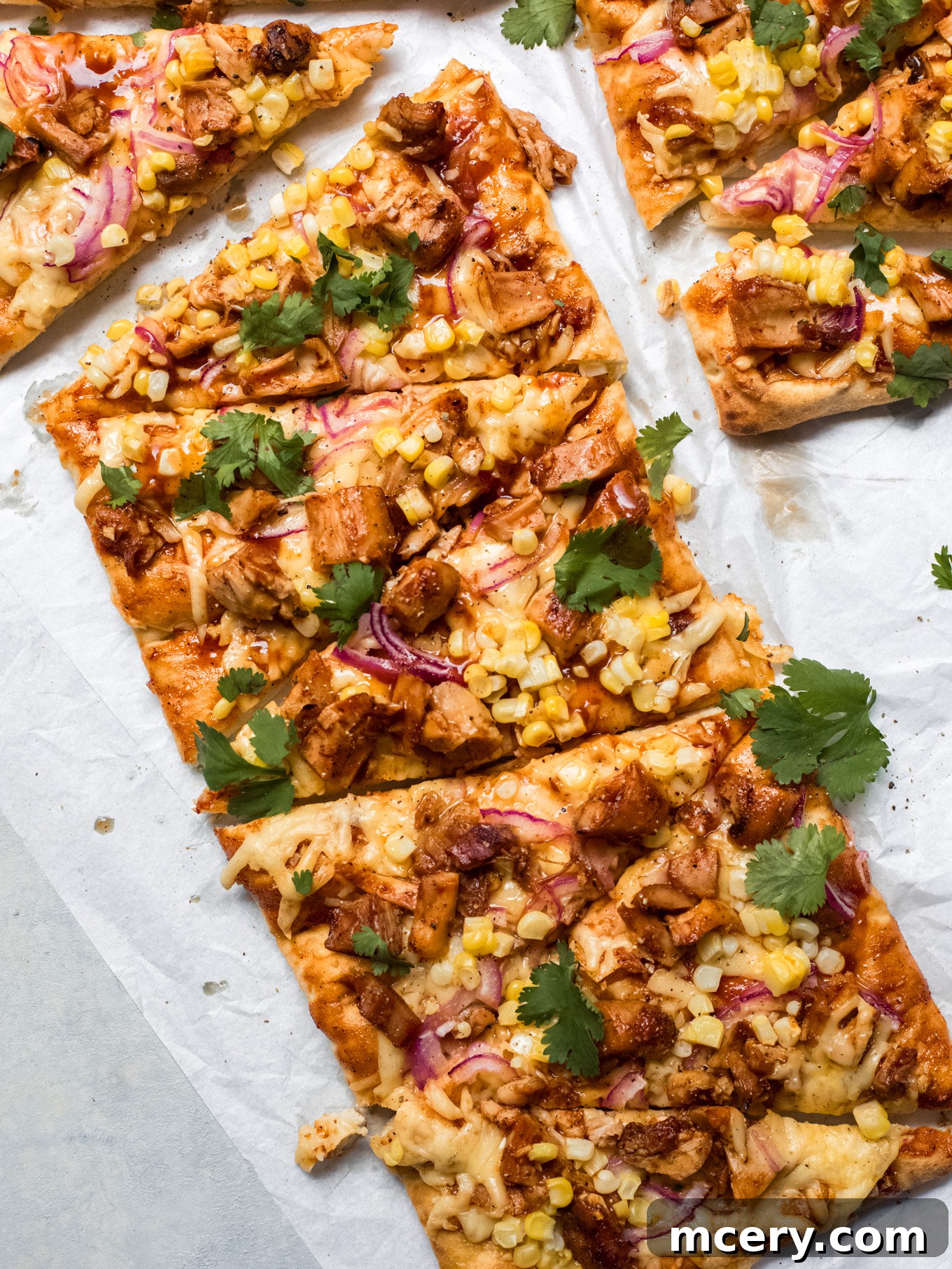 Smoky BBQ Chicken Flatbread 8 Close-up of a perfectly sliced BBQ chicken flatbread, showing the melted cheese, chicken, corn, and cilantro.