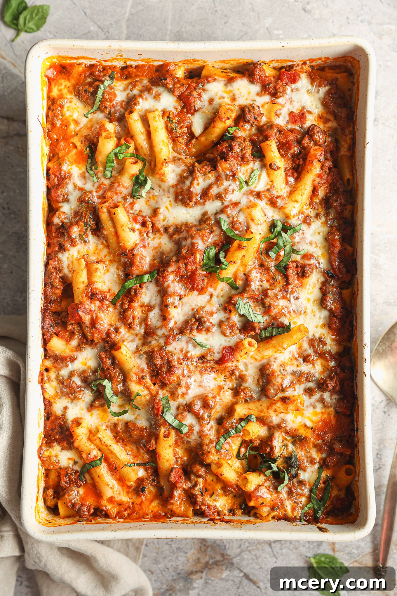 Golden Baked Ziti Delight 2 A delicious baked ziti pasta in a white baking dish, showing layers of pasta, rich meat sauce, and melted, golden-brown cheese.