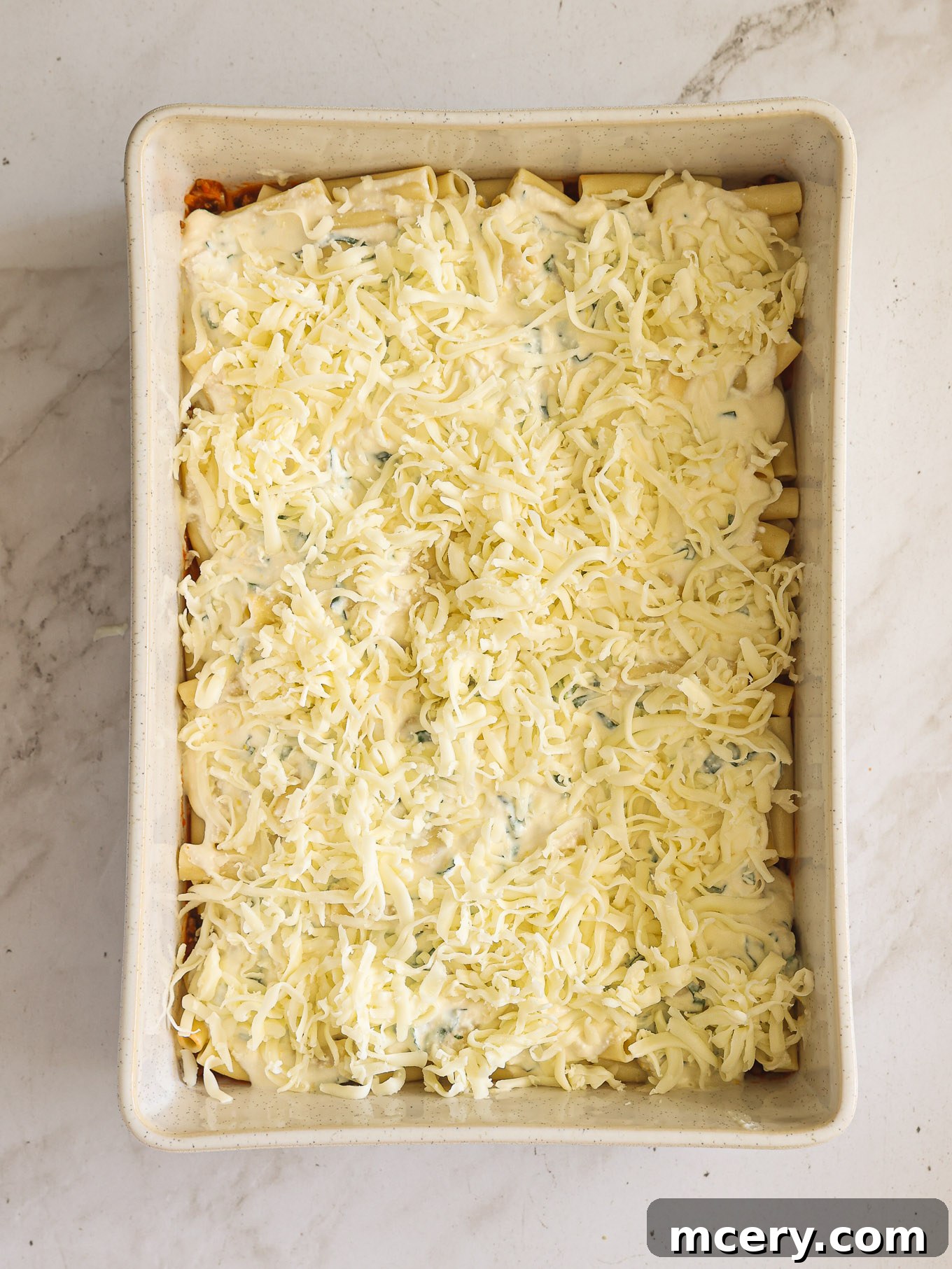 Golden Baked Ziti Delight 10 Shredded mozzarella cheese generously sprinkled over the ricotta and ziti layers.