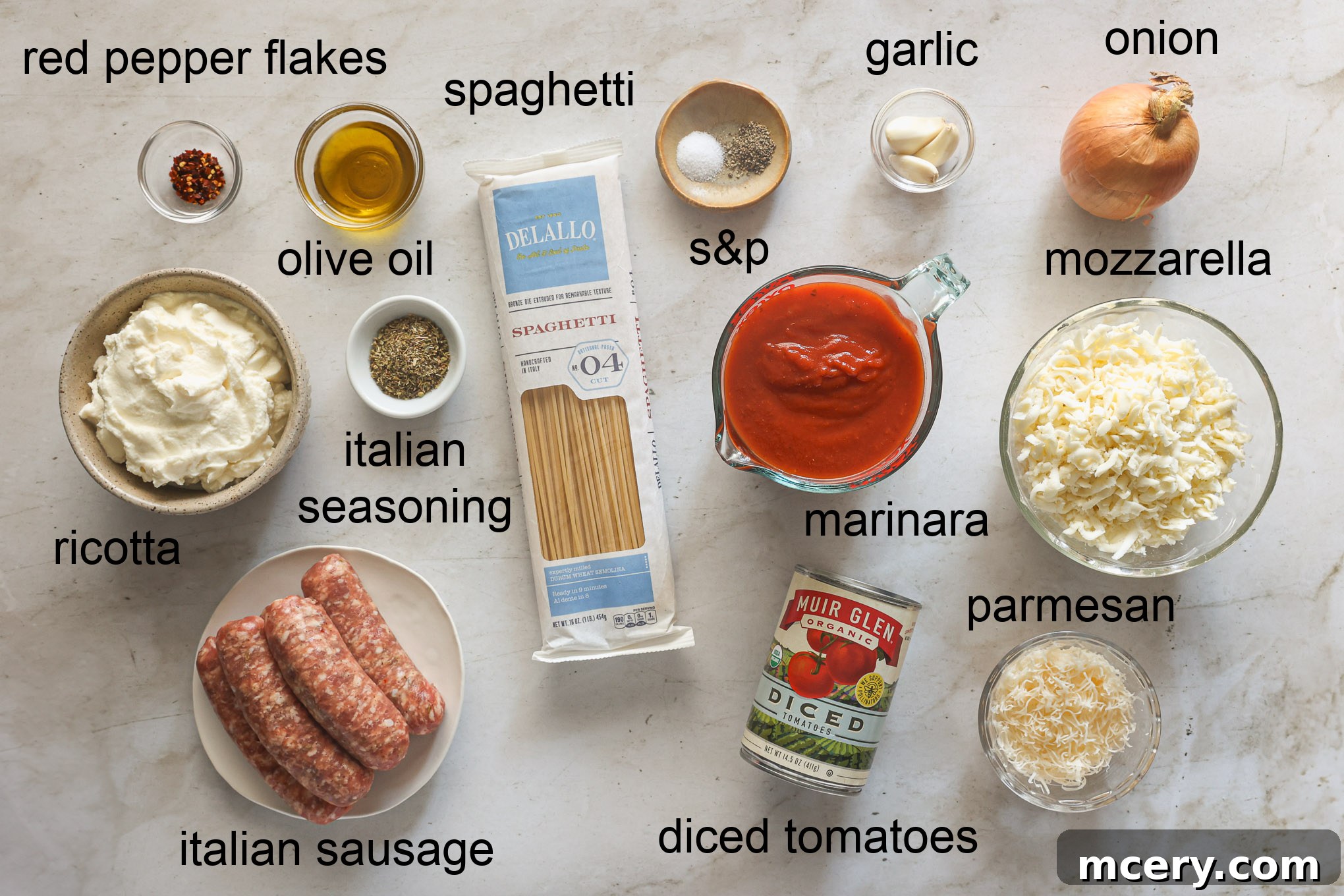 Effortless Creamy Ricotta Spaghetti Bake 3 All the fresh and pantry ingredients laid out for making the baked spaghetti recipe, including pasta, sausage, vegetables, sauces, and various cheeses.