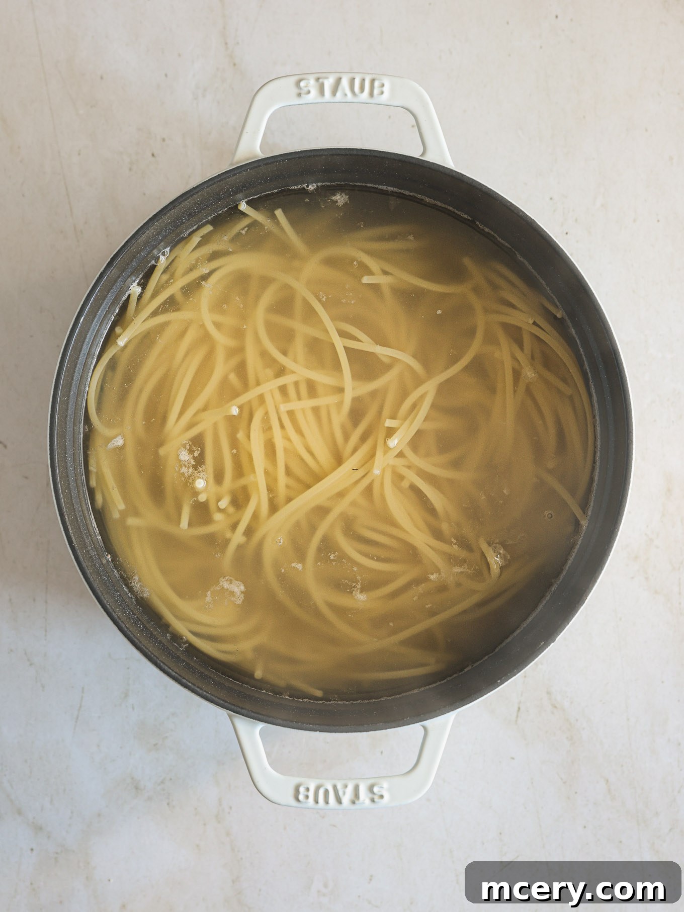 Effortless Creamy Ricotta Spaghetti Bake 4 Cooked spaghetti strands being drained in a colander after boiling, ready for the next step of the baked spaghetti recipe.