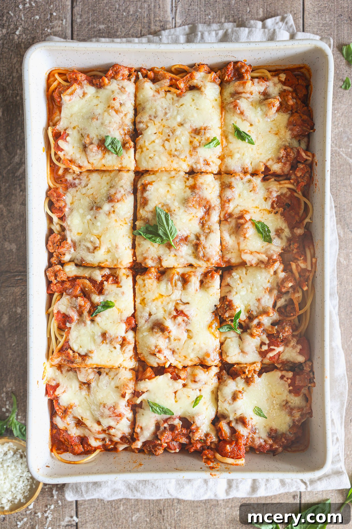 Effortless Creamy Ricotta Spaghetti Bake 10 A serving of baked spaghetti cut into neat squares in the casserole dish, revealing the beautiful layers of pasta, meat sauce, and melted cheese, ready to be lifted and served.