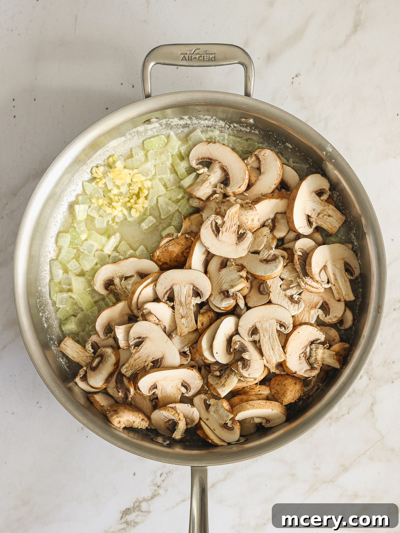 The Ultimate Green Bean Casserole 5 mushrooms with onions and garlic in a saute pan.