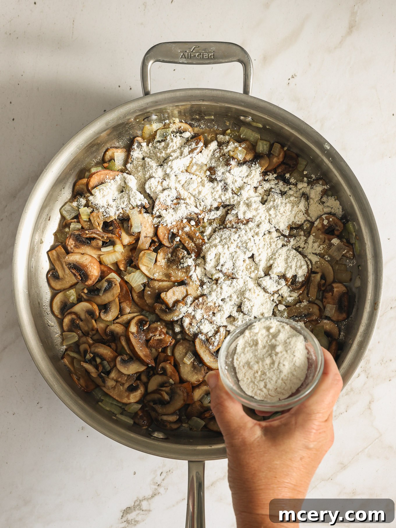 The Ultimate Green Bean Casserole 6 flour sprinkled over cooked mushrooms in saute pan.