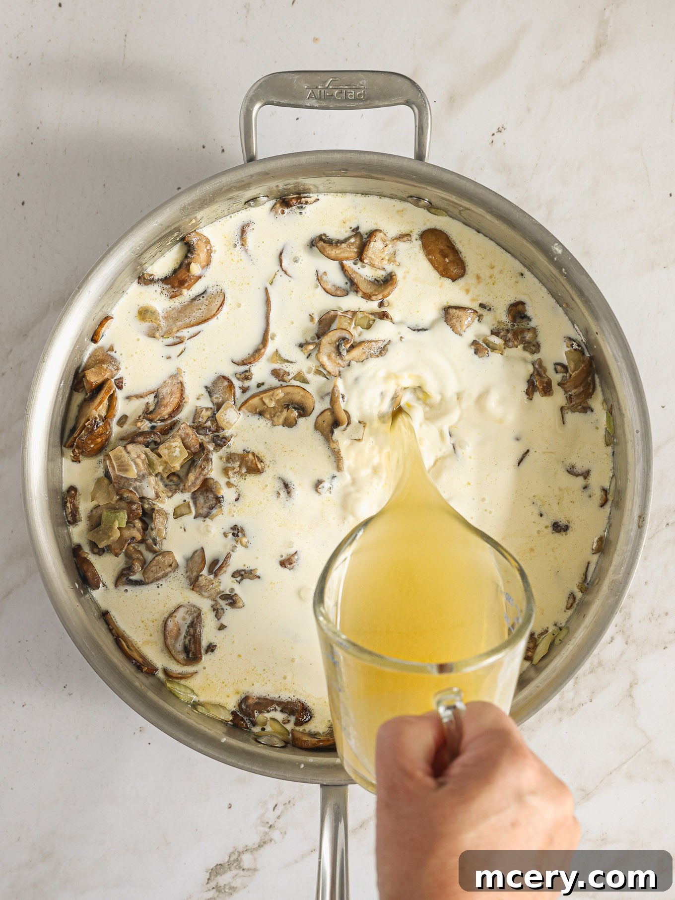 The Ultimate Green Bean Casserole 7 cream sauce with mushrooms in saute pan.