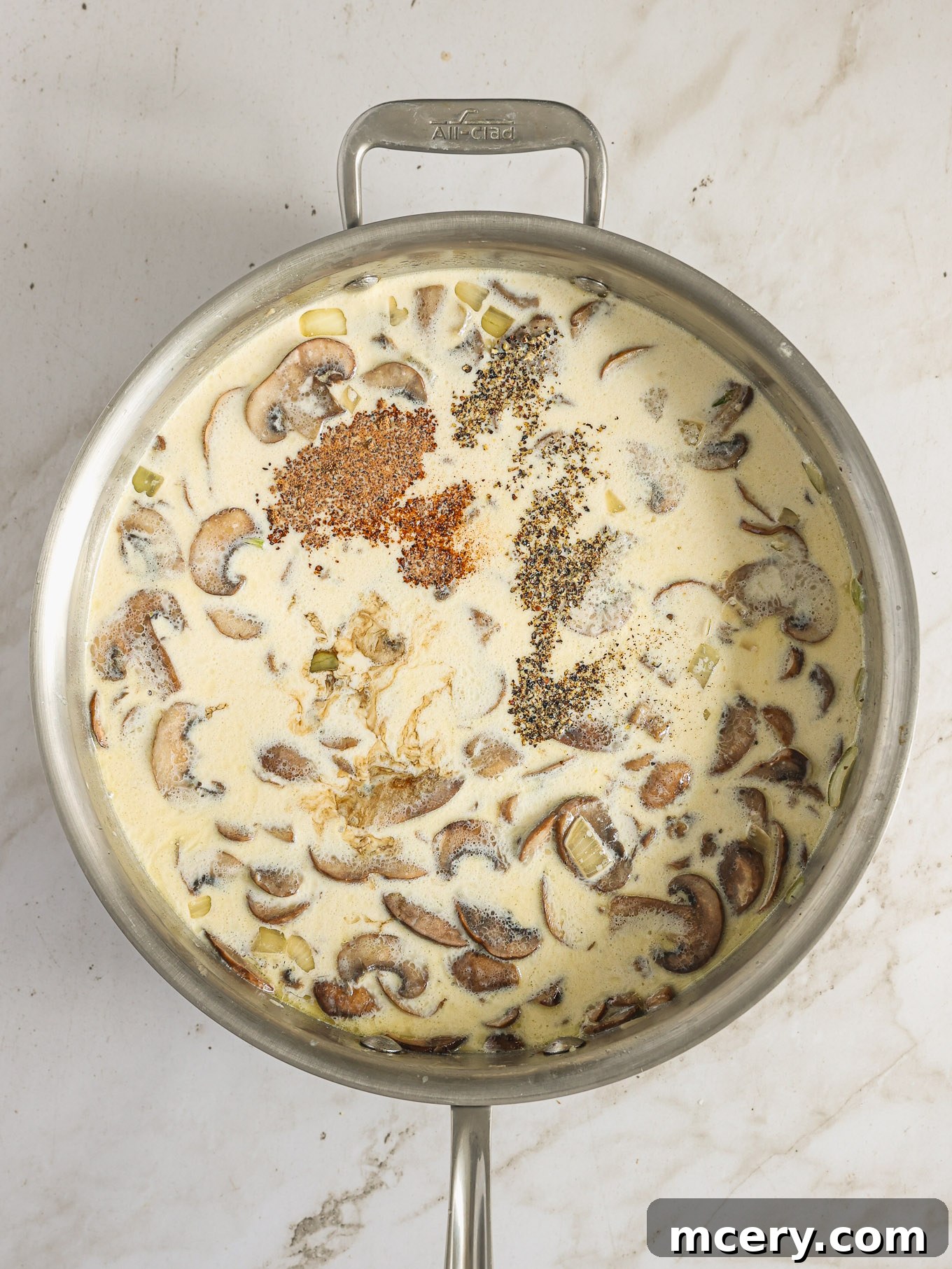 The Ultimate Green Bean Casserole 8 spices over cream sauce in saute pan.