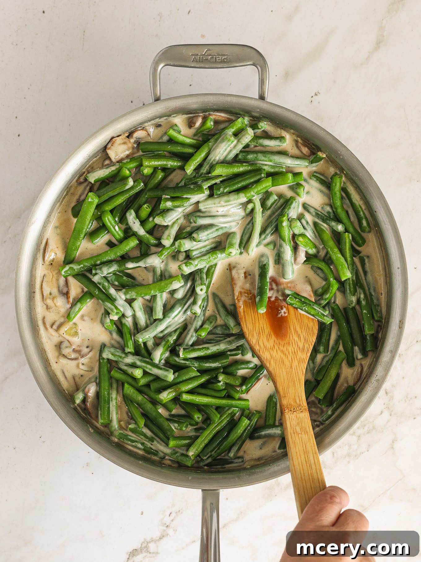 The Ultimate Green Bean Casserole 9 green beans with cream mushroom sauce in saute pan.