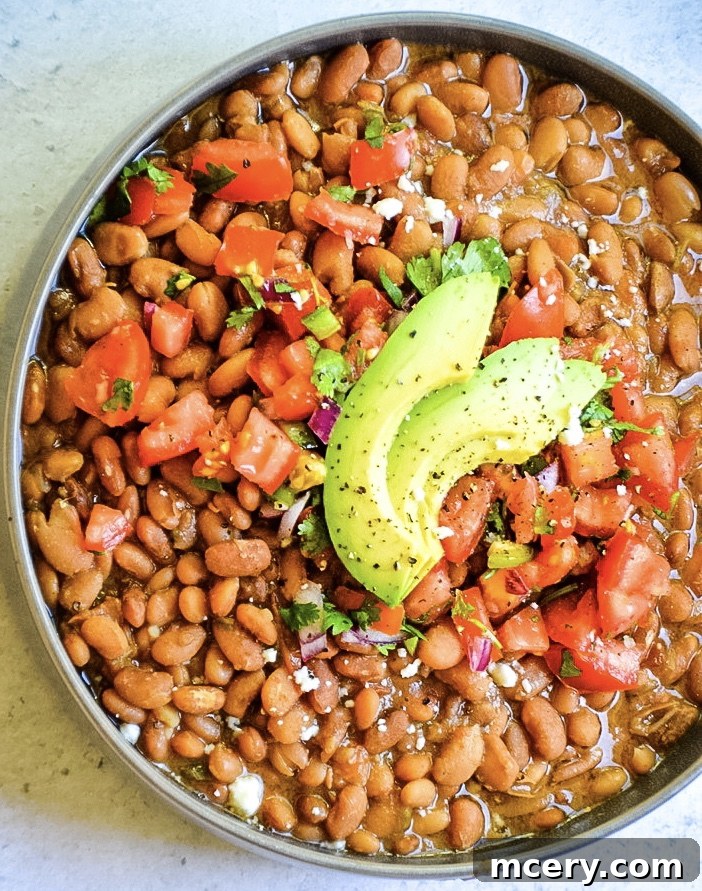 Speedy & Savory Instant Pot Pinto Beans 2 A vibrant bowl of Instant Pot Pinto Beans, garnished with fresh cilantro and a lime wedge, ready to be served.