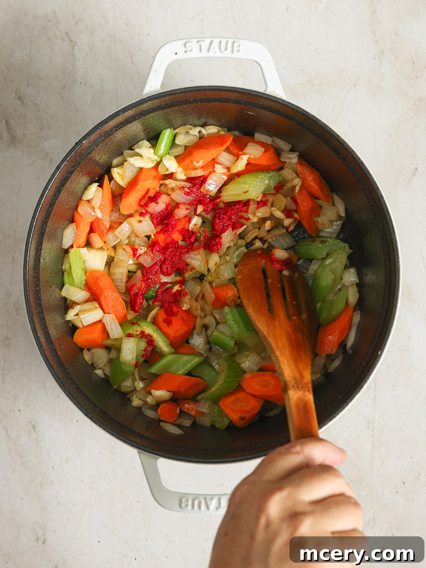Richly cooked vegetables with concentrated tomato paste thoroughly stirred in, caramelizing to deepen the stew's umami.