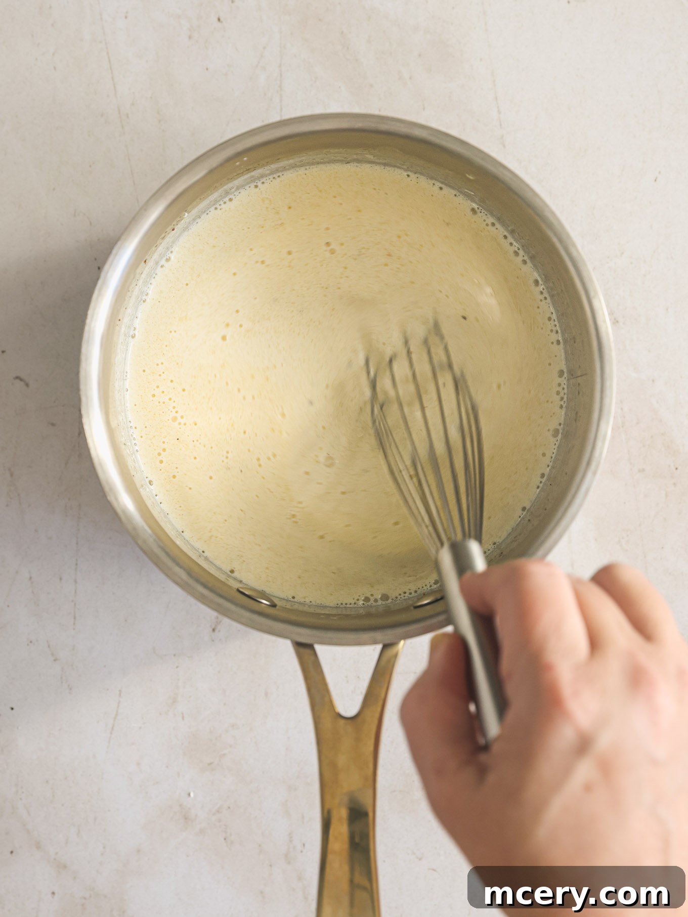 Homemade Alfredo Perfection 7 Smooth, creamy homemade Alfredo sauce being whisked gently in a saucepan, ready for serving.