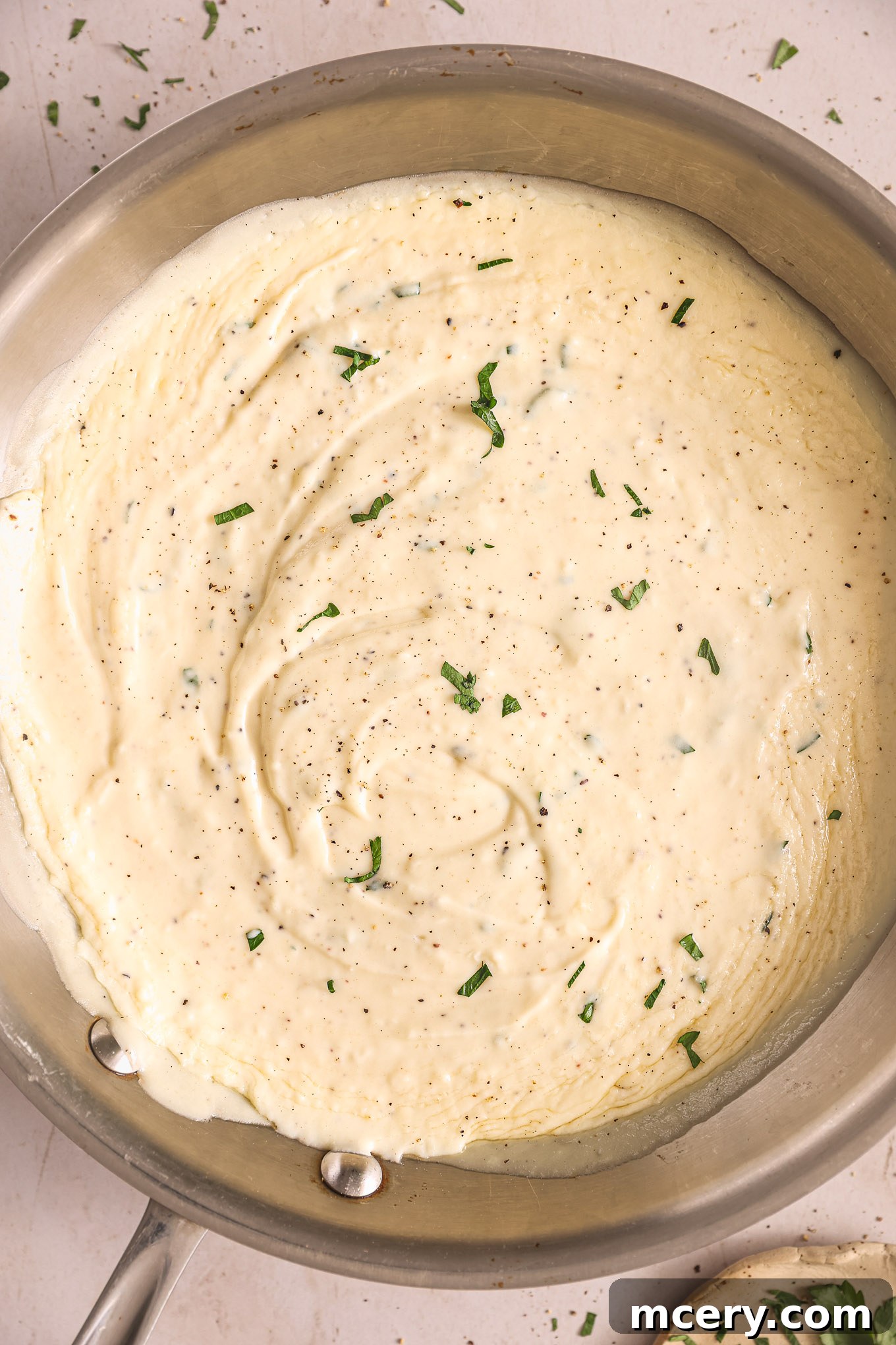 Homemade Alfredo Perfection 8 Homemade Alfredo sauce looking perfectly creamy and smooth in a stainless steel sauté pan, ready to be served.