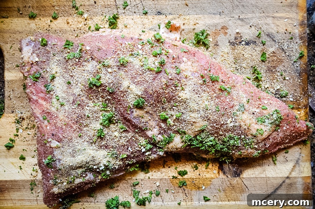A seasoned Tri-Tip roast marinating in a clear ziplock bag with avocado oil, ready for cooking.