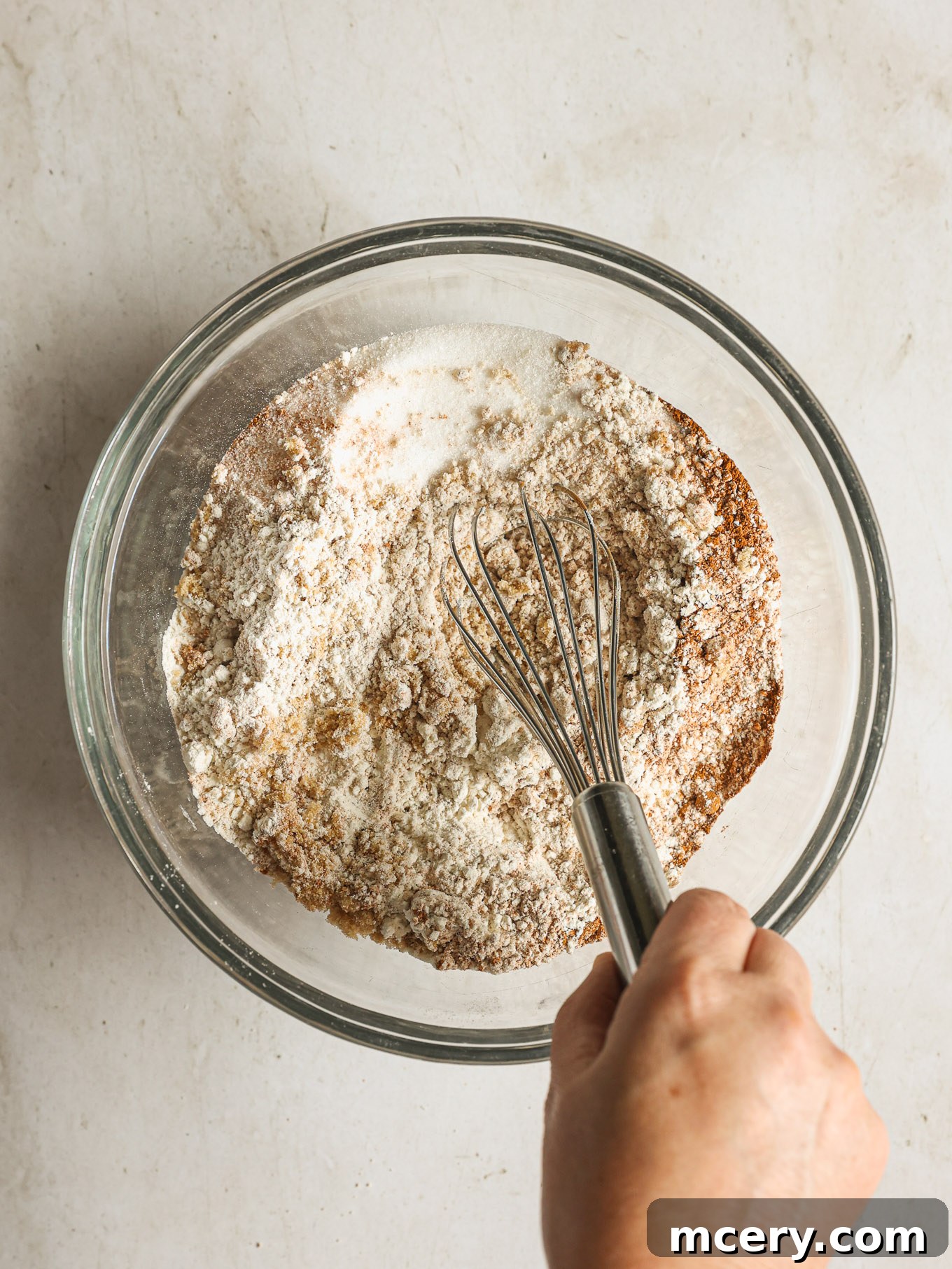 Cozy Pumpkin Crumble Coffee Cake 6 All the dry ingredients for the coffee cake batter, including flour, baking powder, spices, and sugars, are whisked together in a large mixing bowl.